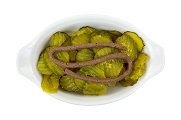 Sweet pickles in a dish with anchovy paste on top