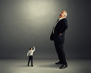 man showing fist to big businessman