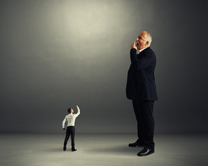 Fototapeta premium man showing fist to big yawning businessman