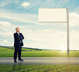 man standing on the road against billboard