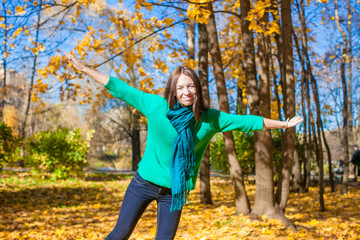 Happy young woman enjoy her autumn vacation in park