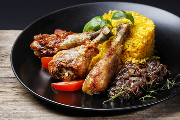 Roasted chicken with vegetables on black plate
