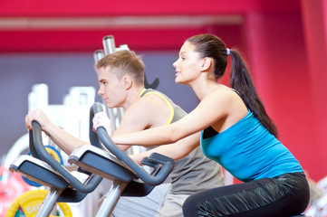 Fototapeta na wymiar People in the gym doing cardio cycling training