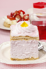 Pink cream cake on pink background. Birthday party table