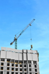 Fototapeta premium Crane lifting concrete mixer container against blue sky