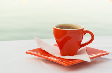 Red coffee cup eith a view of the sea
