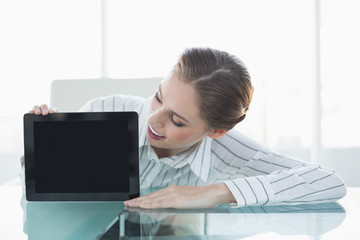 Gorgeous cheerful businesswoman presenting tablet sitting at her
