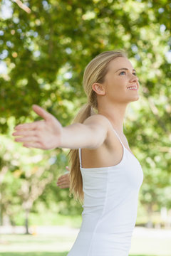 Side view of cheerful attractive woman doing yoga spreading her