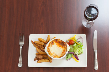 High angle view of lasagna with potatoes and salad