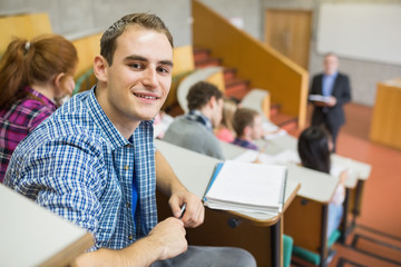 Smiling male with students and teacher at lecture hall