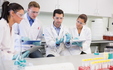 Scientists with tablet PC working on an experiment at lab