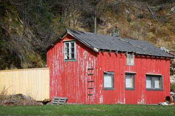 Obraz premium Small abandoned red wooden rural Norwegian house