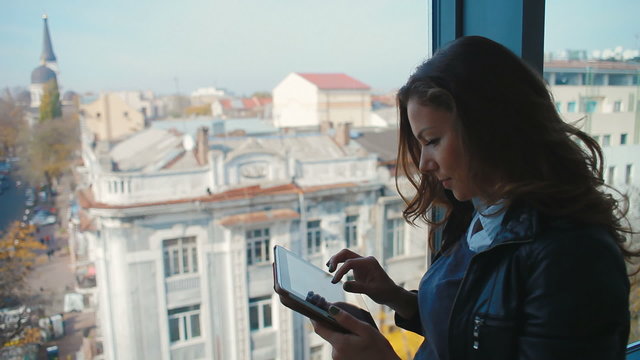 girl tourist near a window with tablet computer