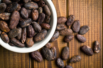 cocoa beans in bowl on wooden table