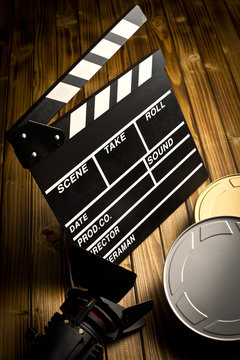 clapper board with movie light and film reels