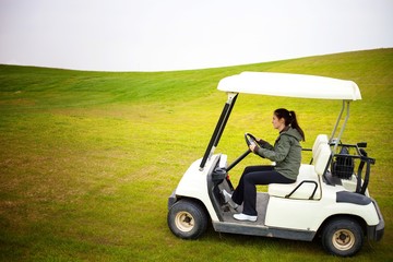 Young woman driving golf cart