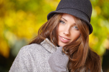 Elegant brunette  woman standing in a park in autumn