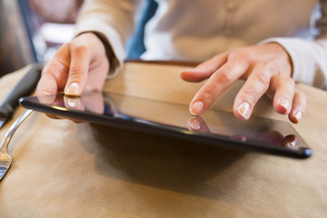 Woman using tablet pcin a cafe, surfing web