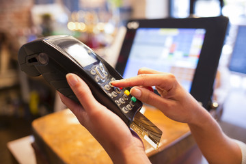Woman hand with credit card swipe through terminal for sale
