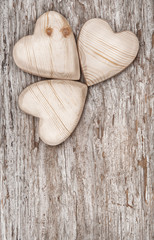 Three wooden hearts on the old wood