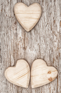 Three wooden hearts on the old wood