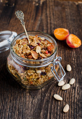 Homemade granola in a glass jar on a vintage board