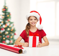 smiling girl in santa helper hat with gift box