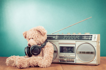 Retro toy Teddy Bear and radio recorder in front mint background