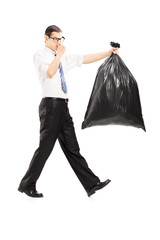 Male closing his nose and carrying a stinky garbage bag
