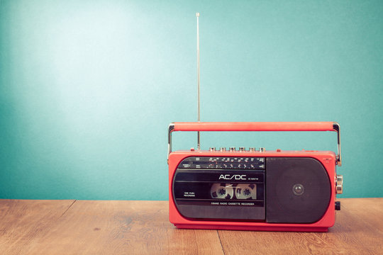 Old retro red radio cassette recorder on table