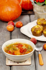 Bowl of tomato and pepper soup on wooden table. Autumn setting.