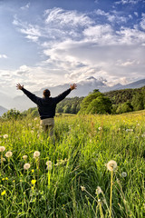 One man with arms outstretched in alpine landscape vertical