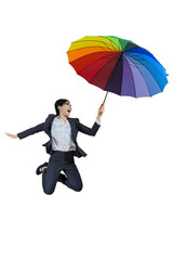 Businesswoman jumping with umbrella