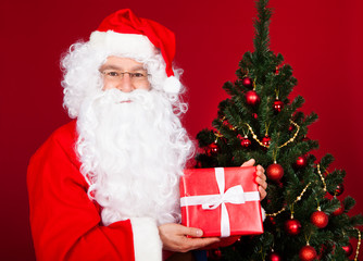 Portrait of a happy santa holding gift