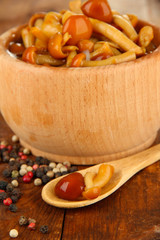 Mushrooms in bowl, on wooden background