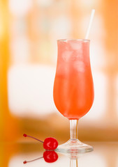 Cherry cocktail with ice on room background