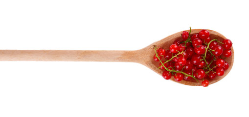 Red currant in wooden spoon isolated on white