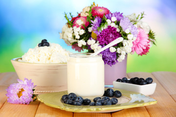 Fresh dairy products with blueberry on wooden table close-up