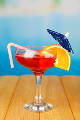 Tasty cocktail on swimming pool background