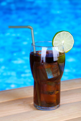 Tasty cocktail on swimming pool background