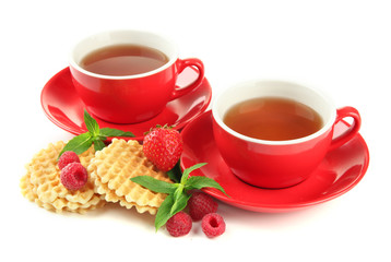 Cups of tea with cookies and berries isolated on white