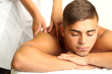 Fototapeta na wymiar Young man having back massage close up