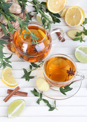 Kettle and cup of tea with ginger on wooden table
