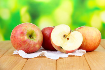 Ripe apples on  wooden table, on bright background
