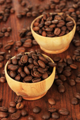 Coffee beans in bowls on wooden background