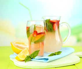 Basil lemonade with strawberry in  jug and glass,
