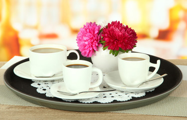 Cups of coffee on tray on table in cafe