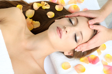 Fototapeta na wymiar Beautiful young woman during facial massage in cosmetic salon