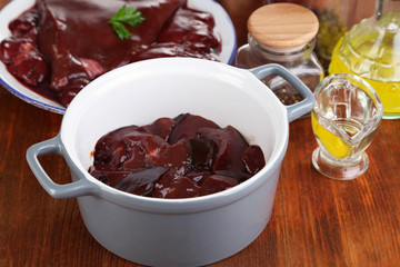 Raw liver in pan with spices and condiments