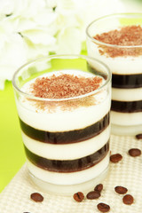 Tasty jelly coffee with milk on table on light background